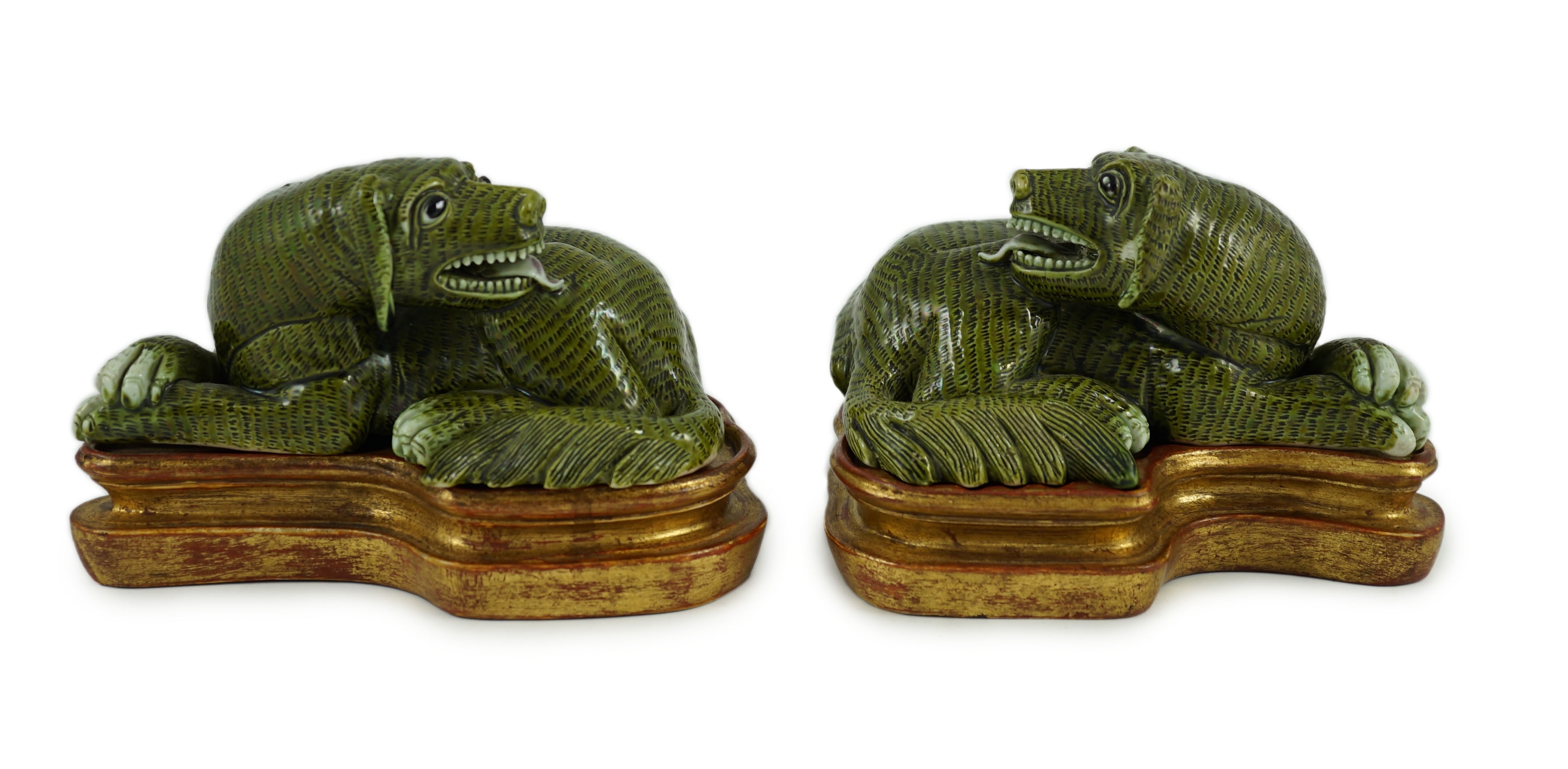 A pair of Chinese green glazed models of hounds, 19th century, 13. 5 cm long, wood stands